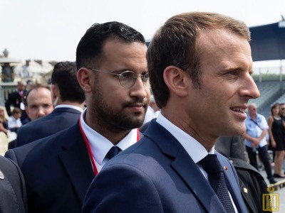 A picture taken on July 14, 2018 shows French President Emmanuel Macron (R) walking ahead of then top security aide Alexandre Benalla at the end of the Bastille Day military parade in Paris.   French President Macron, trying to curb the most damaging scandal of his presidency so far, on July 20, 2018 fired a top security aide who has been taken into custody after videos emerged showing him strike a young man during a demonstration in Paris in May. The Elysee Palace said that Alexandre Benalla, 26, would be dismissed after "new elements" emerged in the case, namely that he is suspected of unlawfully receiving police surveillance footage in a bid to clear his name. A source close to the inquiry said that three police officers, including two high-ranking officials, have been suspended on suspicion of providing the footage to Benalla. He is facing charges of violence by a public official, impersonating a police officer and complicity in unauthorised use of surveillance footage, the Paris prosecutor's office said. / AFP PHOTO / POOL / PHILIPPE WOJAZER